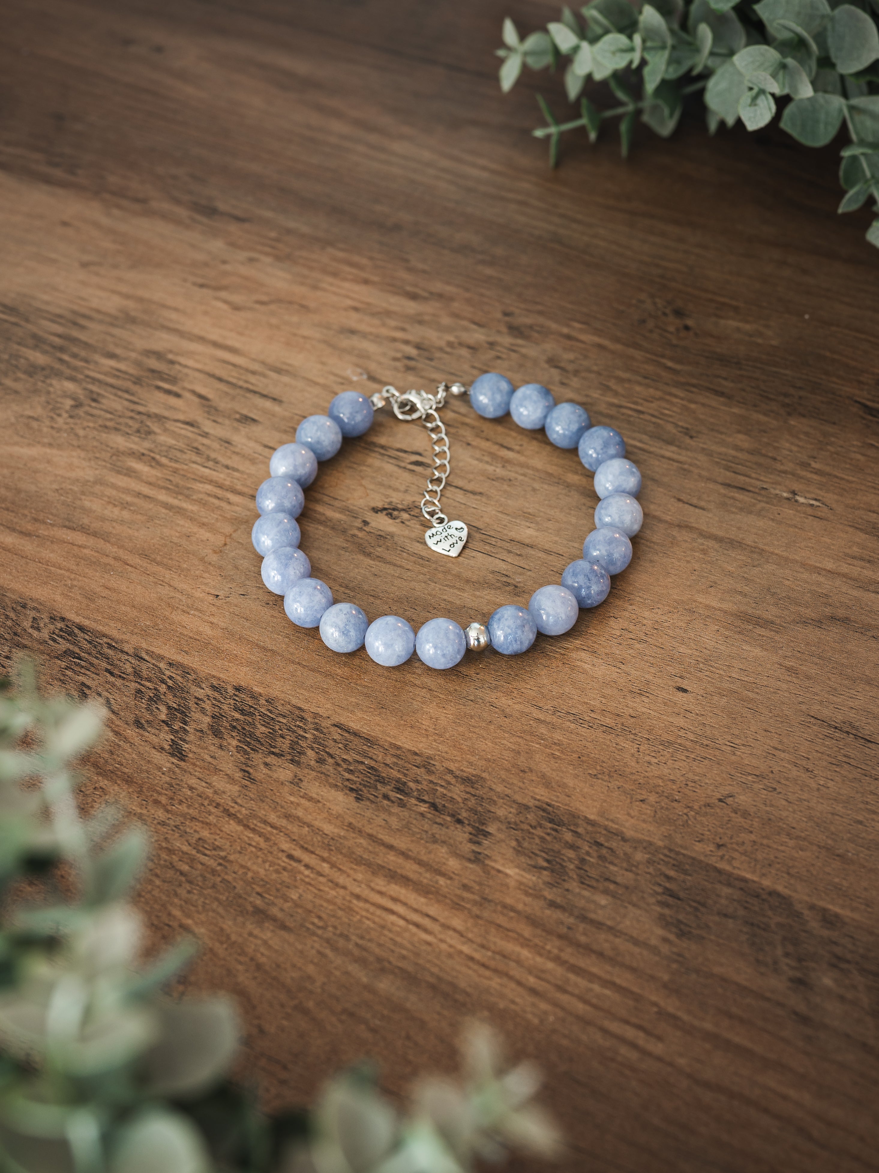 Natural blue angelite stone pet necklace with heart Made with Love charm on a wooden surface