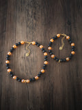 Halloween Bead Pet Necklace – black and orange beads with gold heart charm, shown in two sizes on dark wood